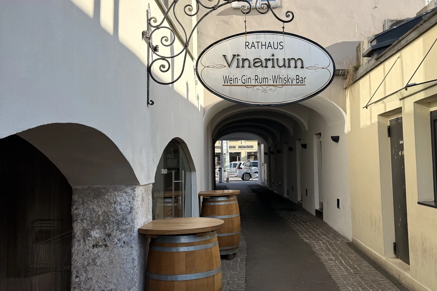 Durchgang beim Rathaus Leibnitz mit Weinfässern und dem Schild der Vinarium-Bar